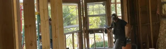 Construction crew installing new wall framing during a home repair