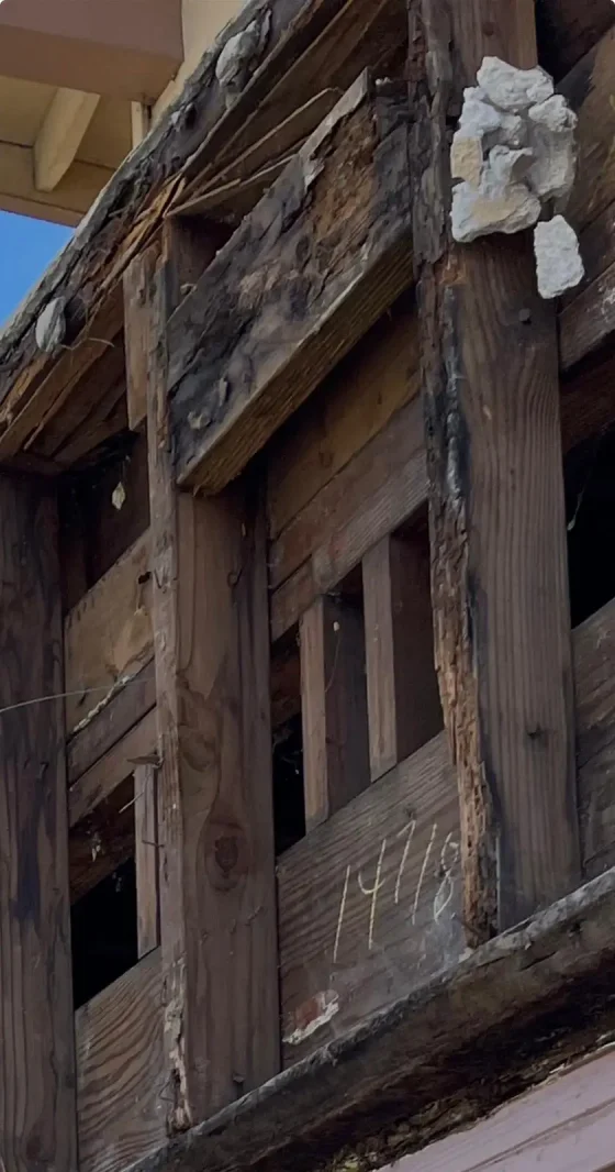 Exterior wall framing exposed with dry rot after siding removal